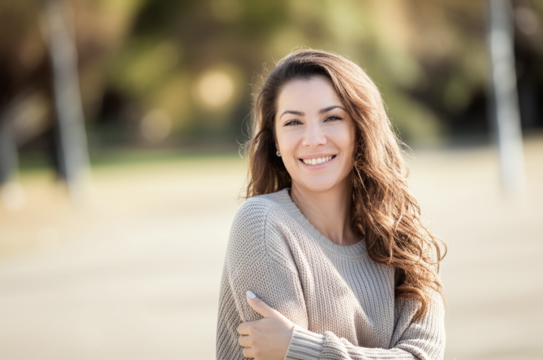 Amor Próprio e Aceitação Mulher sorrindo e abraçando o próprio corpo